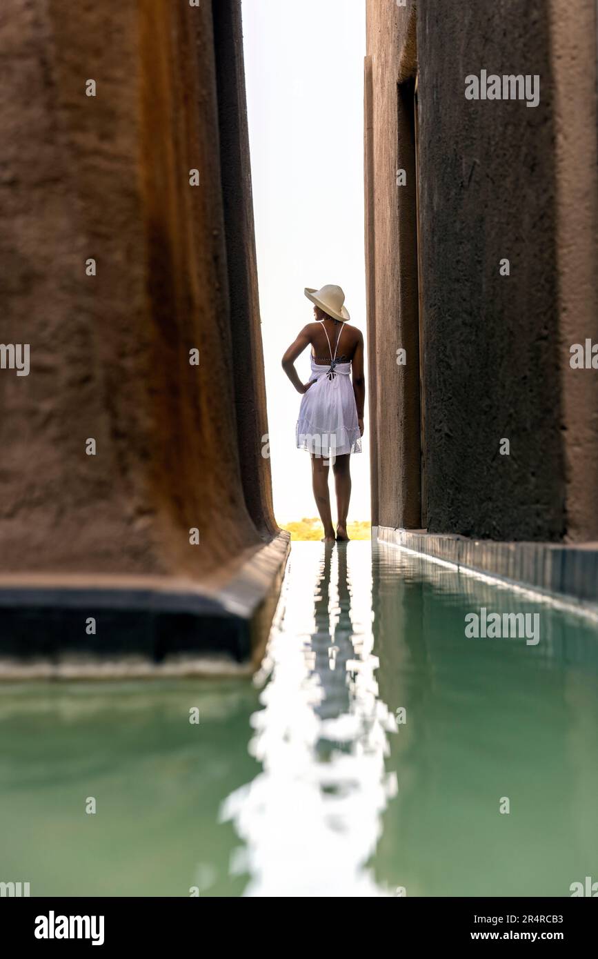 Modèle attrayant debout près de la piscine de réflexion à Onguma le fort, Onguma Game Reserve, Namibie, Afrique Banque D'Images