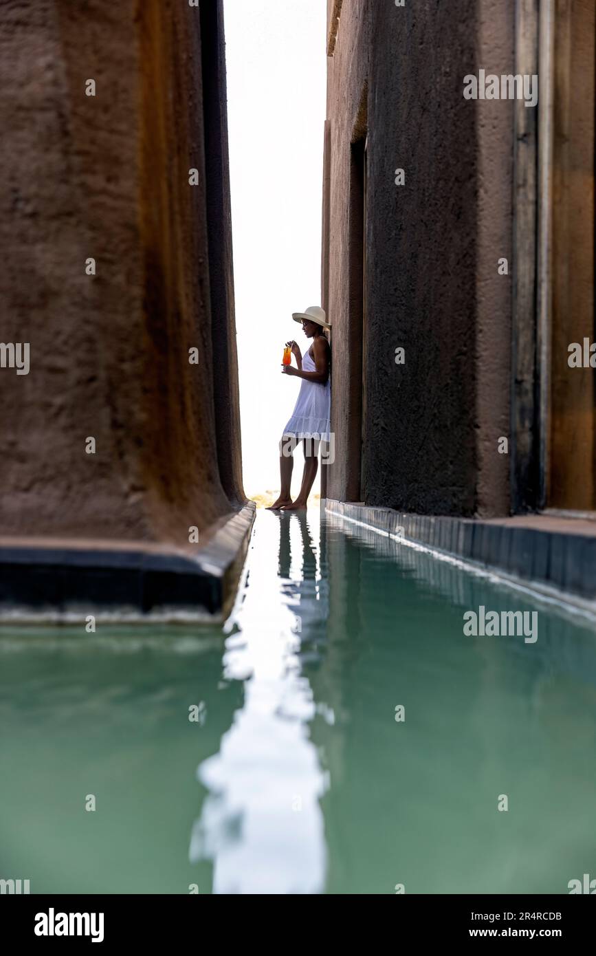 Modèle attrayant debout près de la piscine de réflexion à Onguma le fort, Onguma Game Reserve, Namibie, Afrique Banque D'Images