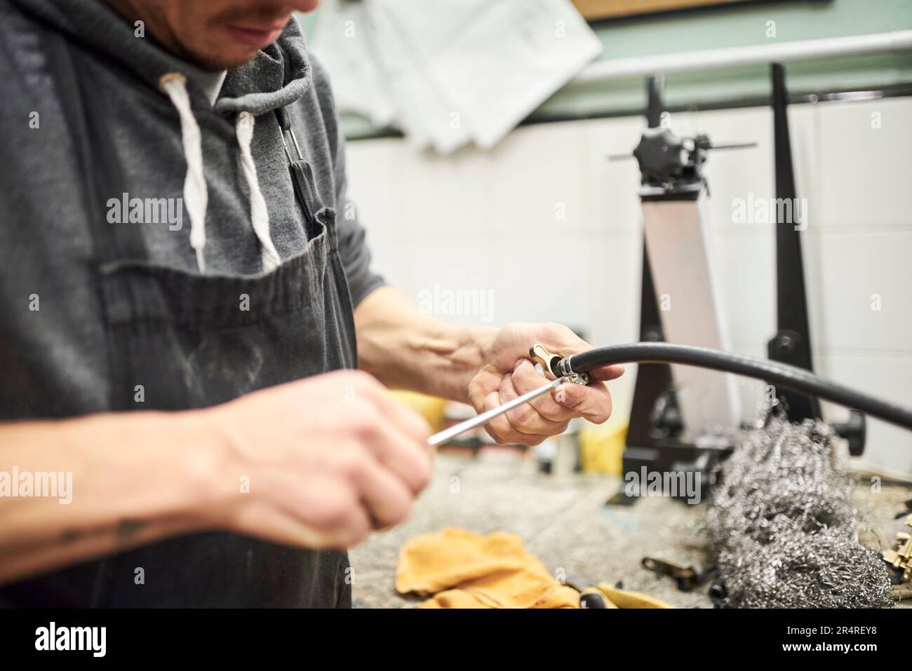 Mécanicien de vélo méconnaissable homme travaillant dans son atelier de réparation de vélo. Banque D'Images