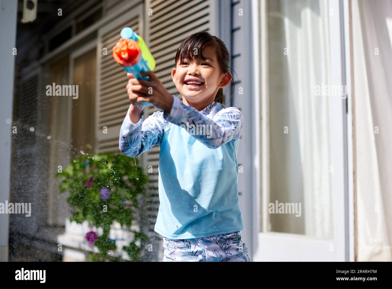 Enfant japonais jouant avec un pistolet à eau Banque D'Images