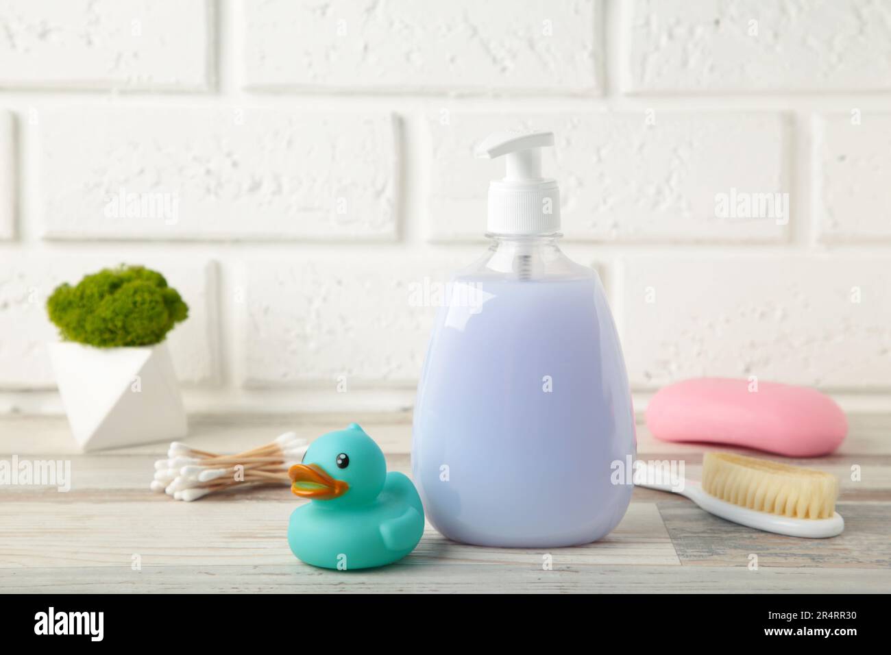 Gel douche pour bébés, savon, canard en caoutchouc, peigne sur la table. Vue de dessus photographie de produits cosmétiques pour bébés Banque D'Images