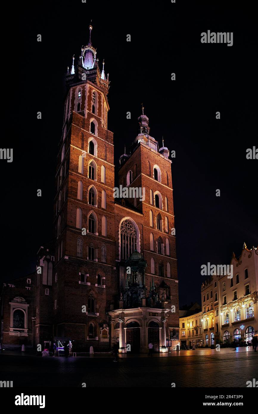 Nuit photo verticale de la place centrale Rynok Glavny avec St. Eglise de Marie à Cracovie en Pologne Banque D'Images