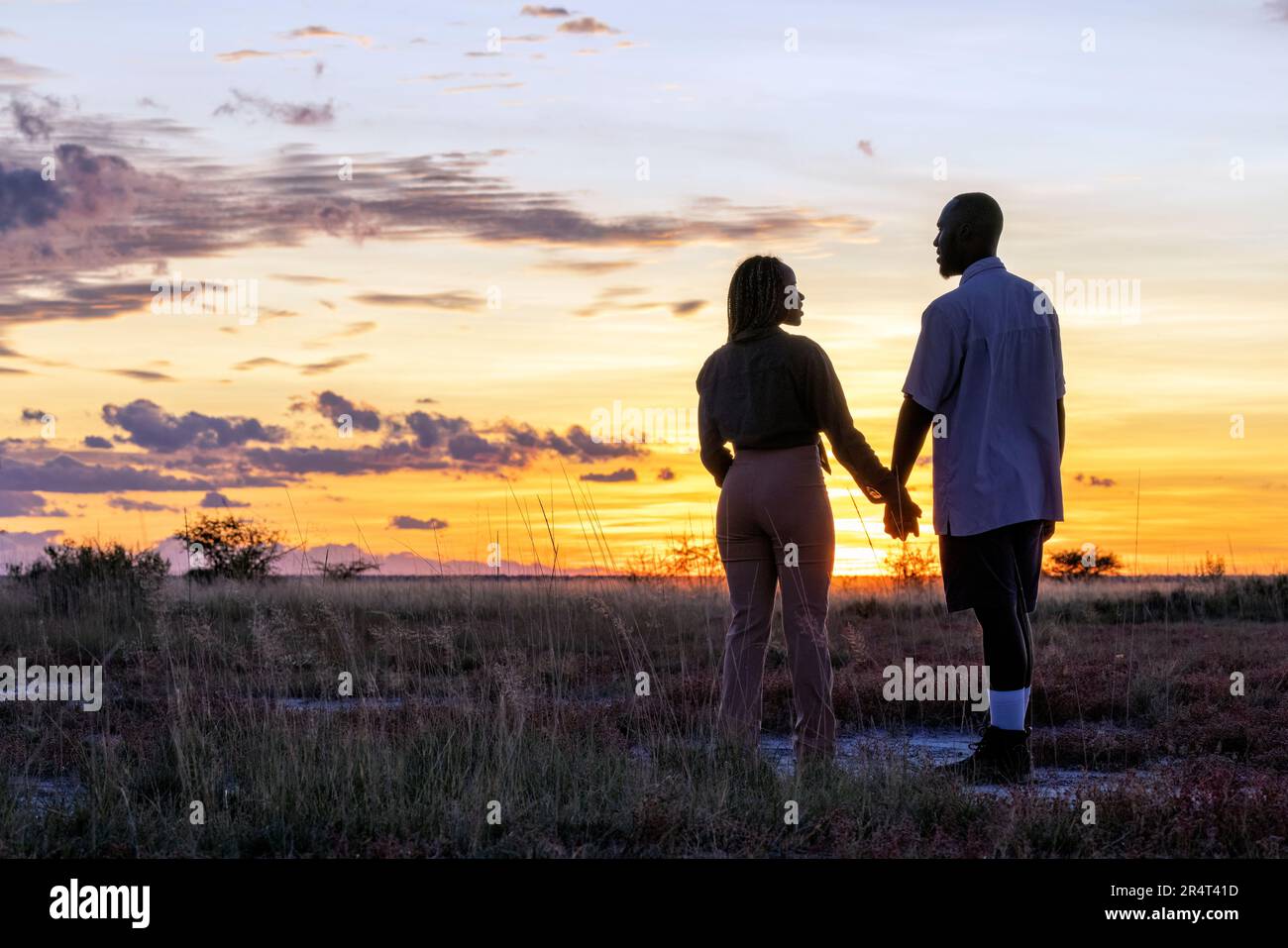 Couple appréciant le coucher du soleil à Onguma Game Reserve, Namibie, Afrique Banque D'Images