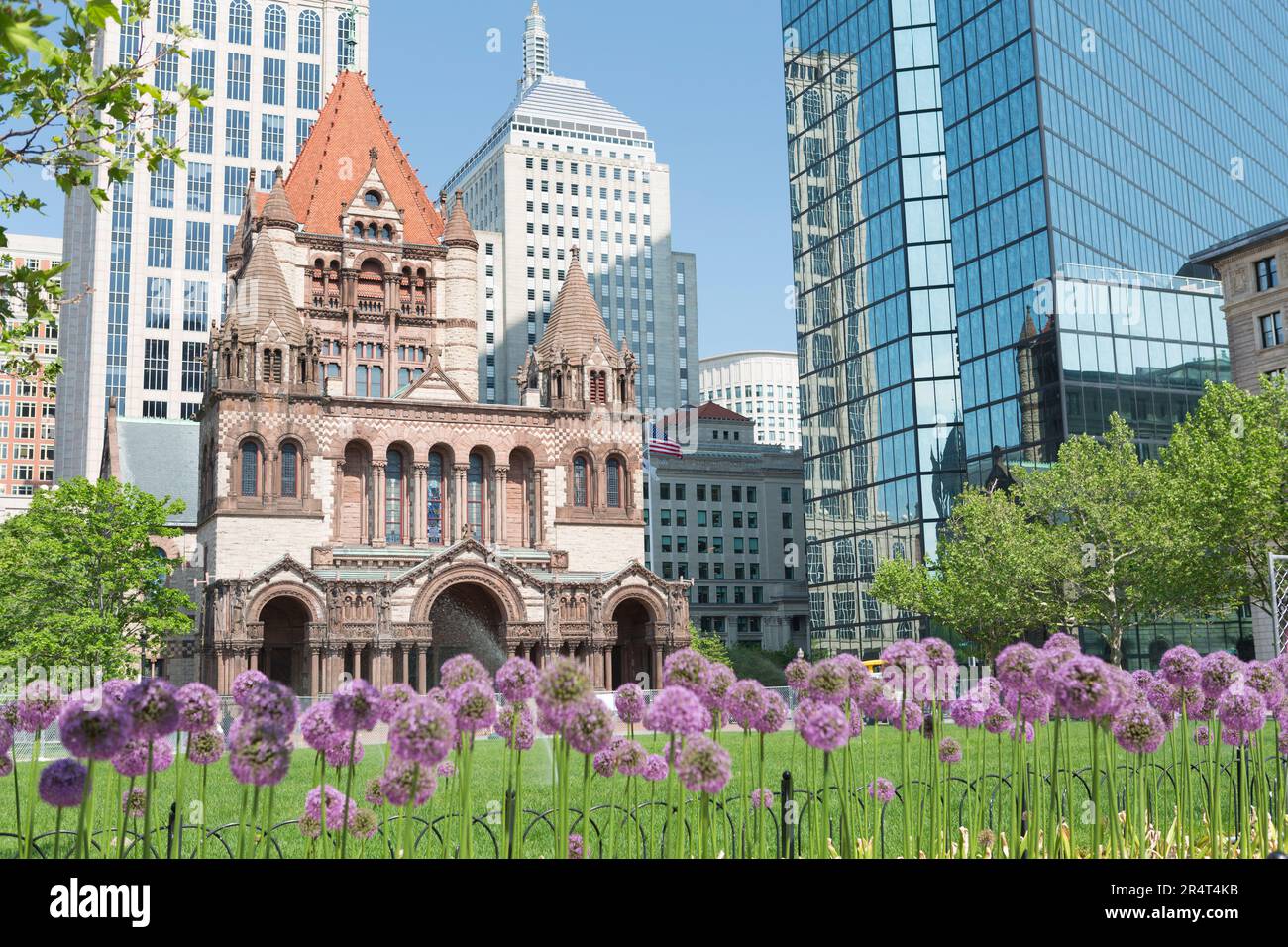 USA, Massachusetts, Boston, Trinity Church et John Hancock Tower avec des fleurs violettes. Banque D'Images