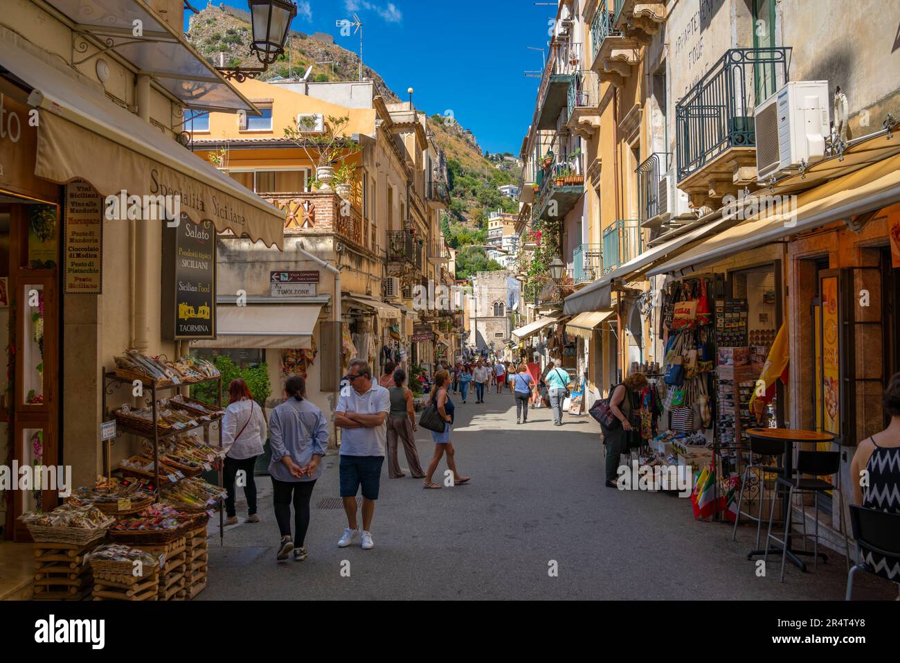 Vue sur la rue animée et l'escalade à flanc de colline en arrière-plan à Taormina, Taormina, Sicile, Italie, Europe Banque D'Images