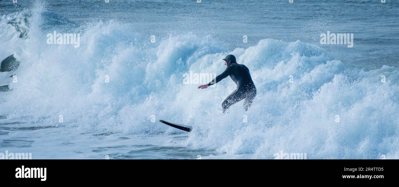 Image panoramique d'un surfeur qui fait une vague à Fistral à Newquay, en Cornouailles, au Royaume-Uni. Banque D'Images