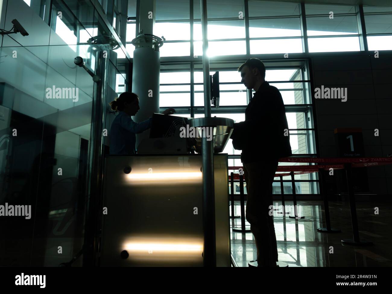 Silhouette d'un passager à la porte avec l'employé vérifiant ses billets. Aéroport international de Zvartnots à Erevan, Arménie. Banque D'Images