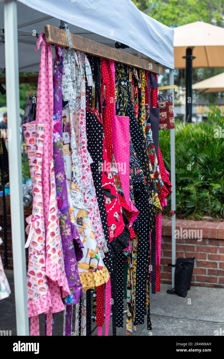 Tabliers de robe chasuble féminins faits main colorés suspendus à un marché à vendre. Les protecteurs de vêtements en coton sont dotés de bavoirs, de volants et de sangles ou de liens. Banque D'Images