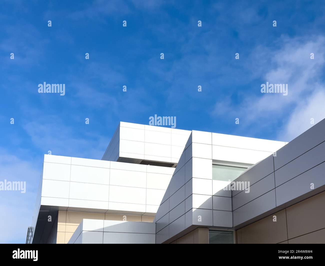 Panneaux composites métalliques externes commerciaux sur un bâtiment avec ciel bleu et nuages en arrière-plan. Les panneaux composites métalliques durables sont deux nuances Banque D'Images