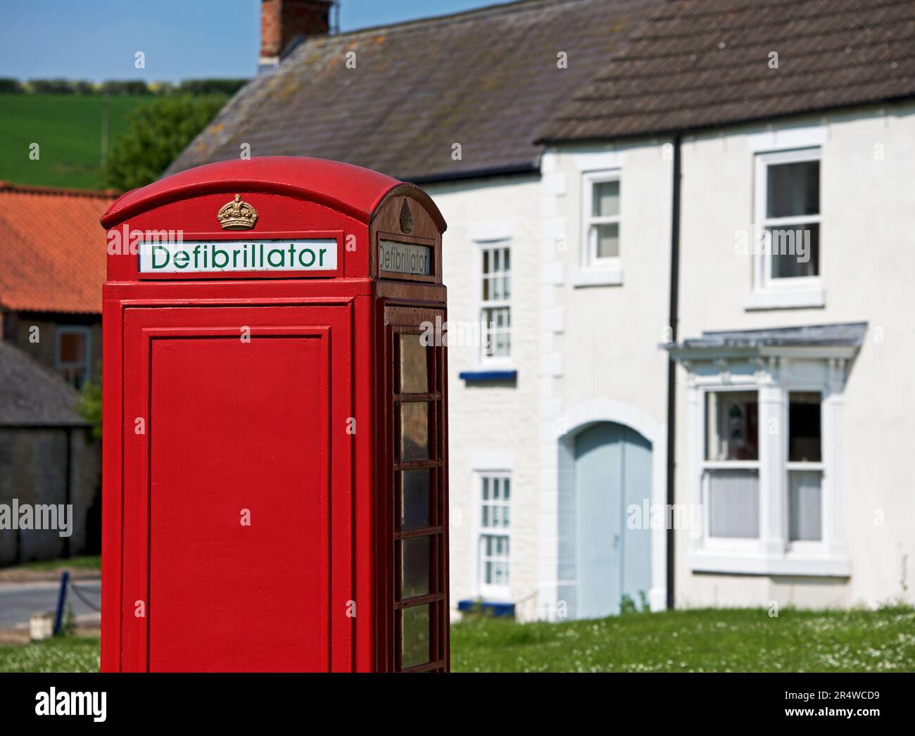 Défibrillateur logé dans un boîtier téléphonique redondant, dans le village de North Newbald, East Yorkshire, Angleterre Banque D'Images