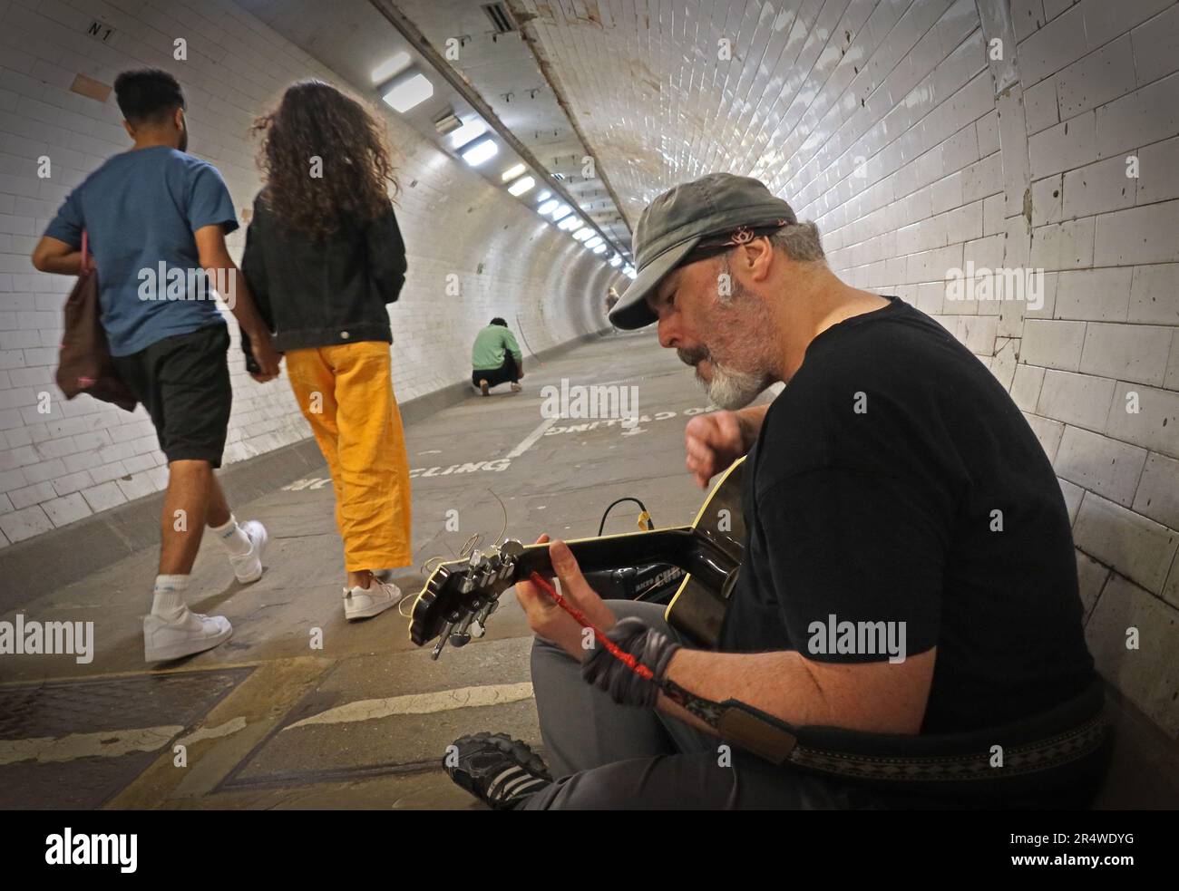Busker dans le tunnel à pied de la Tamise de Greenwich, des randonneurs de divertissement allant de Greenwich à l'île des chiens, est de Londres, Angleterre, Royaume-Uni, SE10 9HT Banque D'Images