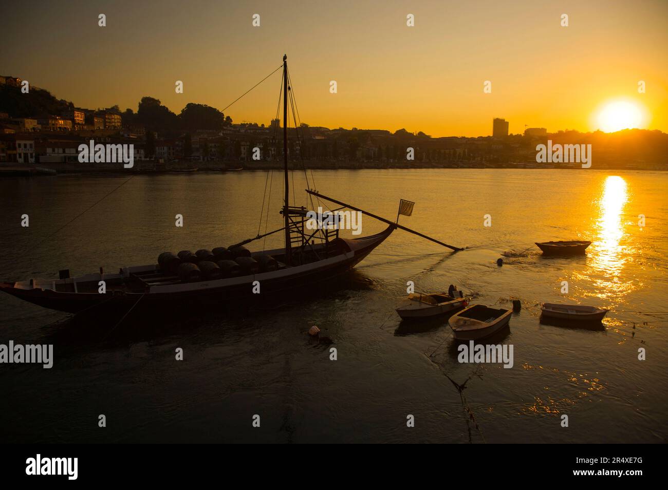 Bateau transportant des tonneaux de vin dans le port de Porto au coucher du soleil ; Porto, Portugal Banque D'Images