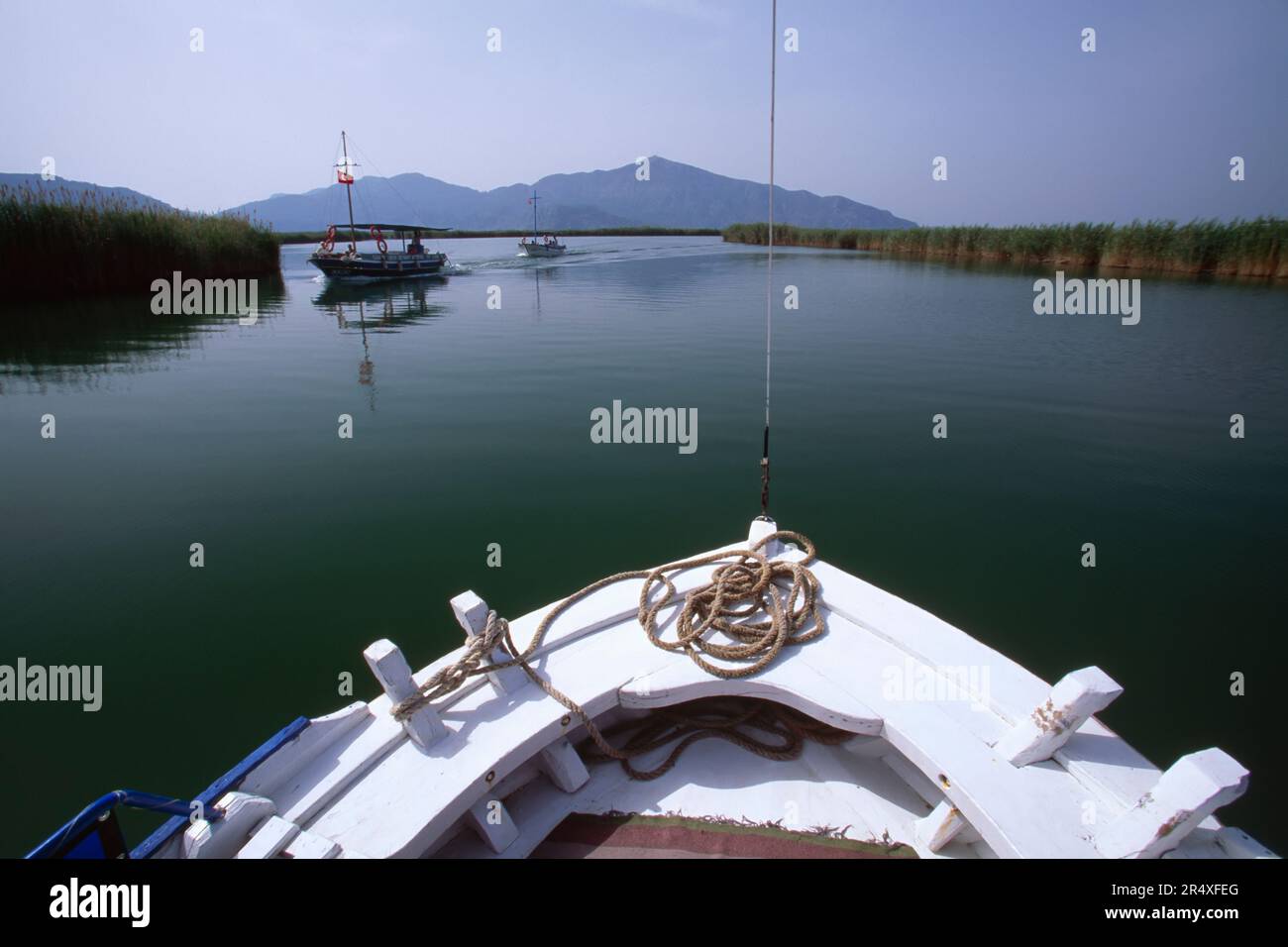 Vue sur une mer plate, des bateaux et des collines au-dessus de la proue d'un voilier blanc ; République de Turkiye Banque D'Images
