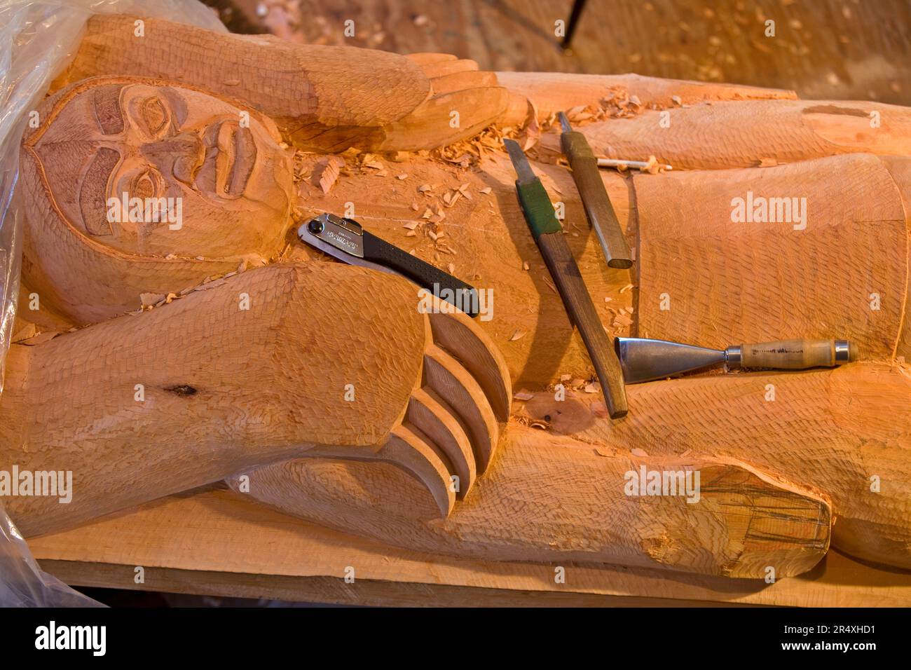 Sculpture sur bois Tlingit avec outils à Saxman Totem Park, Ketchikan, Alaska, États-Unis ; Ketchikan, Alaska, États-Unis d'Amérique Banque D'Images