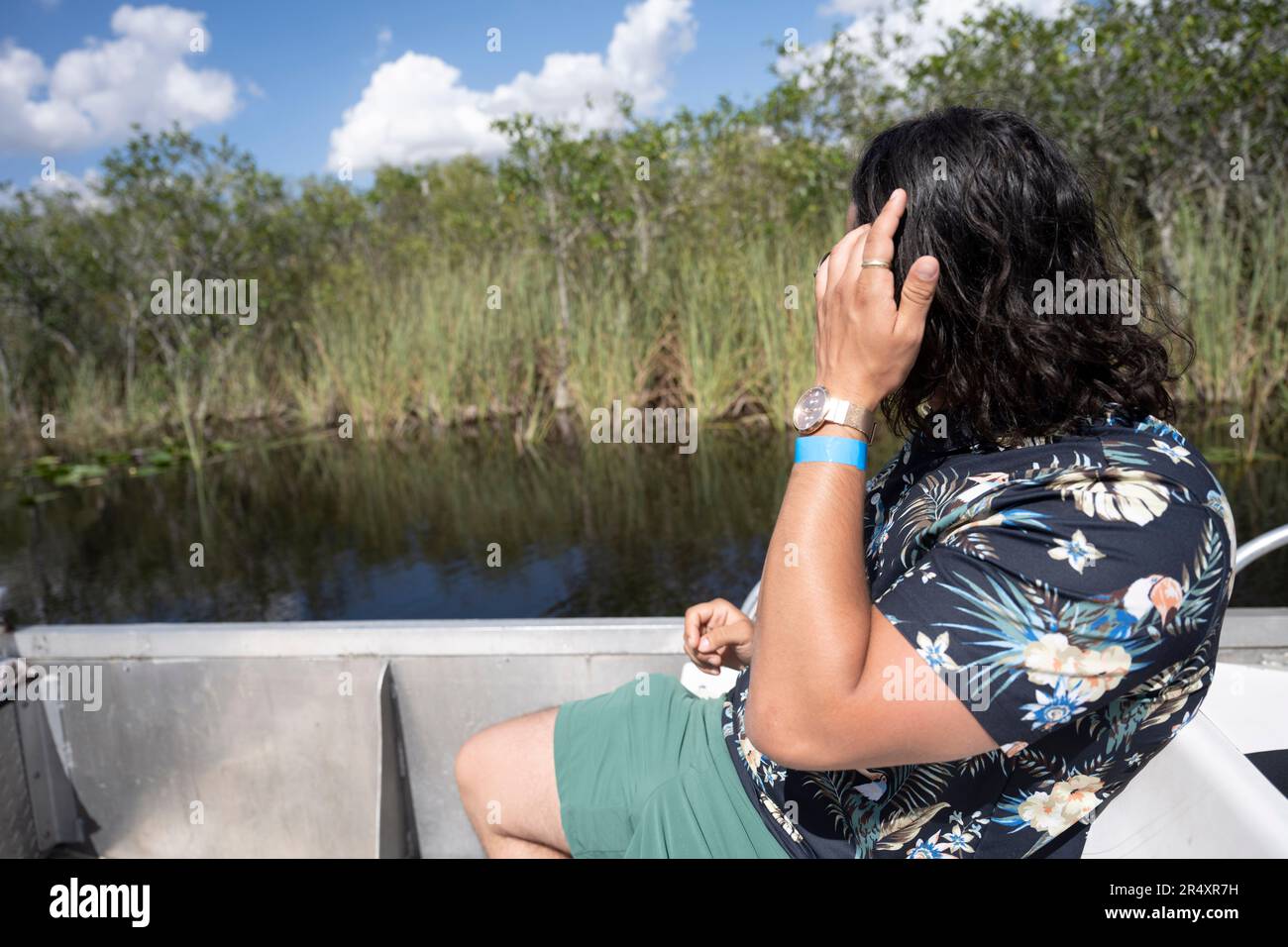 Everglades, Floride, États-Unis. 8th mai 2023. Un touriste regardant les scènes de la nature lors d'une promenade en hydroglisseur.le parc national des Everglades est une merveille naturelle captivante en Floride, aux États-Unis. S'étendant sur plus de 1,5 millions d'acres, il abrite divers écosystèmes, y compris des terres humides, des mangroves et des prairies à herbes hautes. Les visiteurs peuvent explorer sa faune unique, comme les alligators, les oiseaux aquatiques et les lamantins, par la randonnée pédestre, le kayak, ou en prenant des visites guidées, immergeant dans sa beauté à couper le souffle. Écologie, espèces envahissantes, changement climatique, environnement, environnement, crise climatique, réchauffement climatique, vert, Banque D'Images