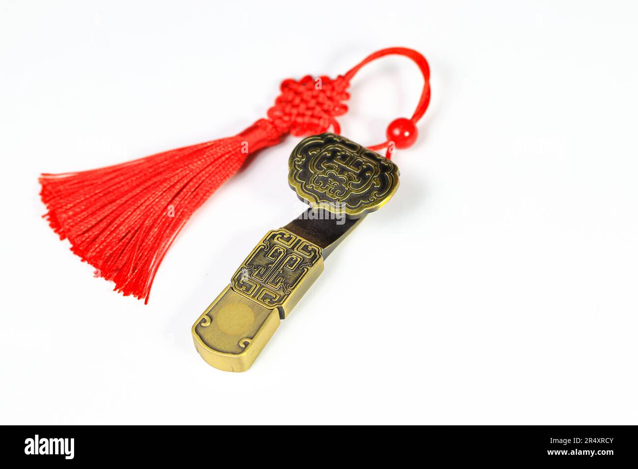 Amulette en laiton chinois traditionnel en cadeau. Amulette de style chinois avec rouge décoratif bonne chance noeuds signifie bonne fortune, bonheur et riche sur blanc Banque D'Images