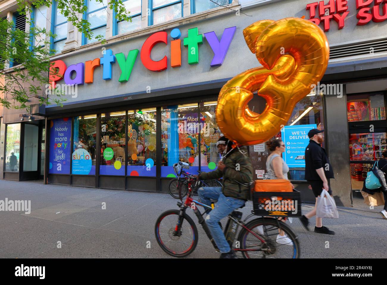 Un service de messagerie à vélo avec livraison de ballons d'un magasin Party City à Manhattan, New York. Banque D'Images