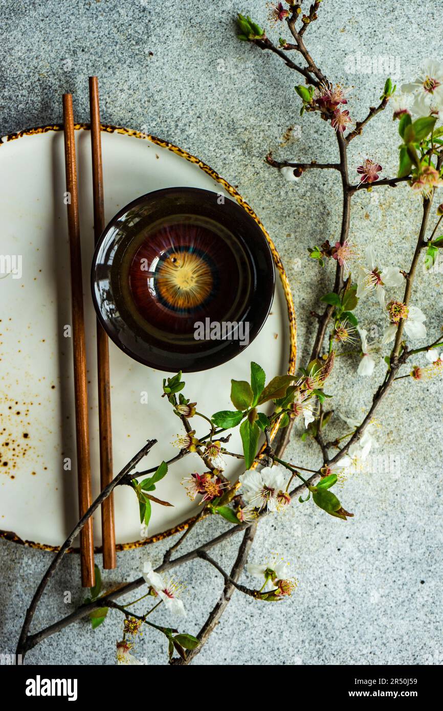 Table de printemps avec baguettes décorées de branches de cerisier en fleurs Banque D'Images
