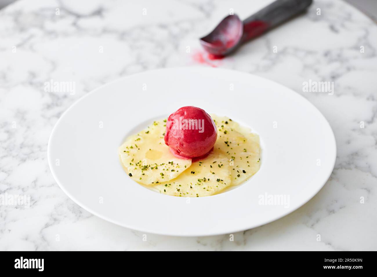 Anneaux d'ananas avec sorbet framboise Banque D'Images
