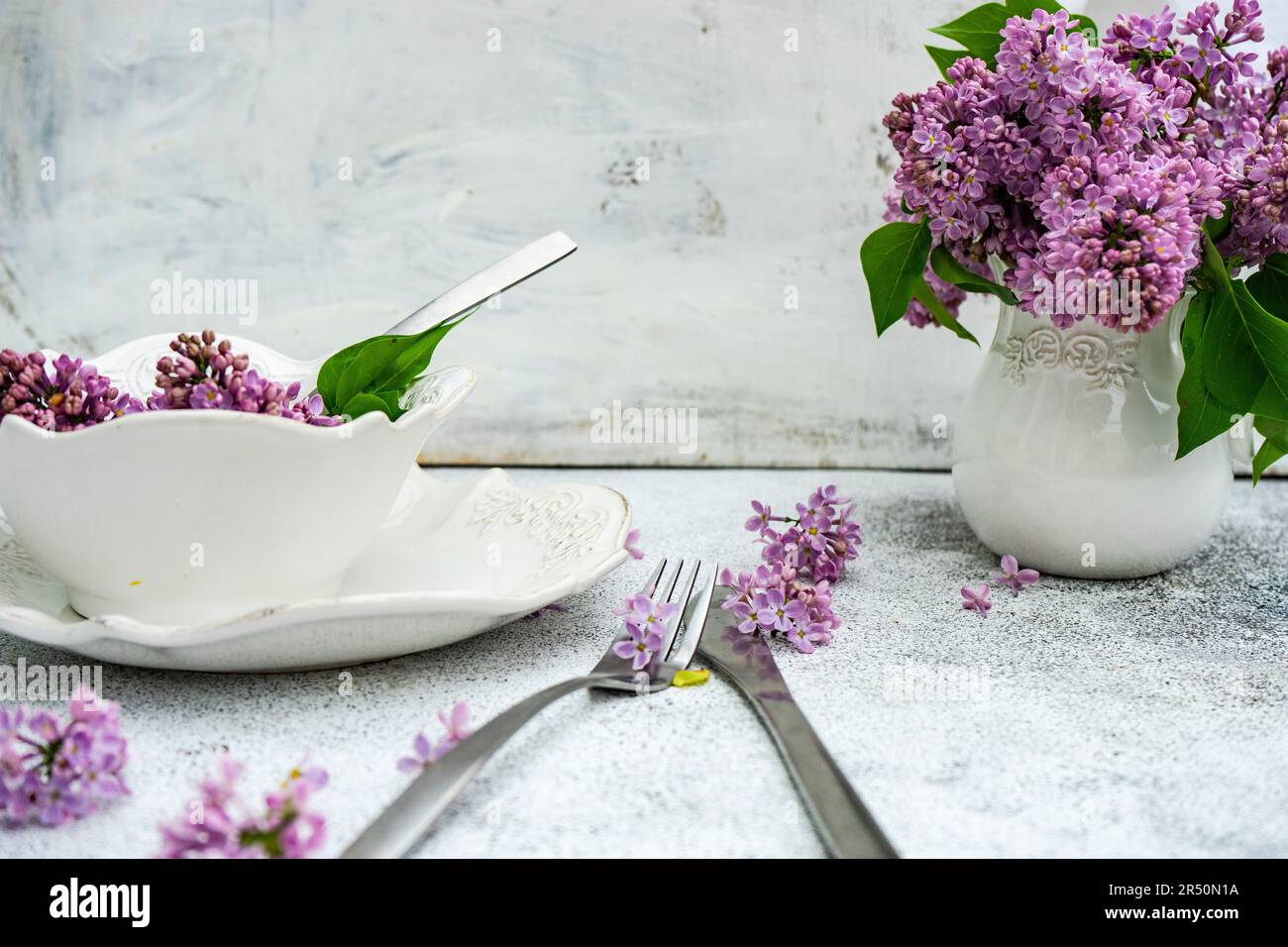 Décor printanier avec fleurs de lilas sur une table extérieure Banque D'Images