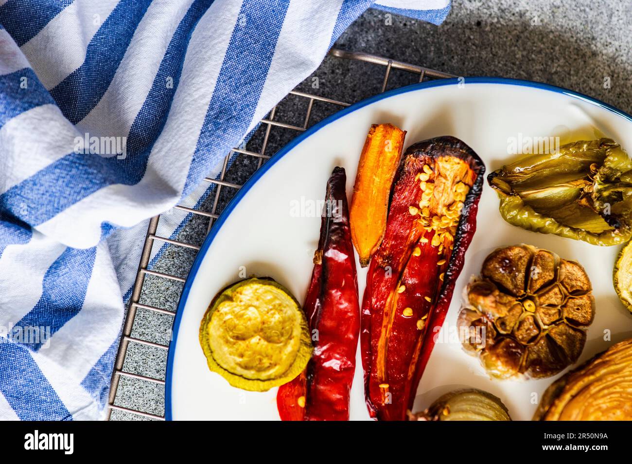 Un dîner sain avec une variété de légumes barbecue servi sur de la vaisselle en céramique avec une sauce à la crème aigre Banque D'Images