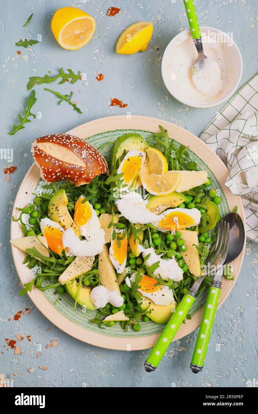 Salade de roquette avec petits pois, avocat, œufs, fromage et vinaigrette à la mayonnaise au