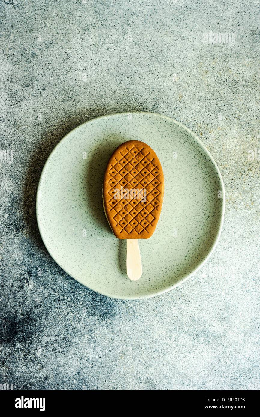 Une seule portion de crème glacée avec biscuit sur l'assiette en pierre Banque D'Images