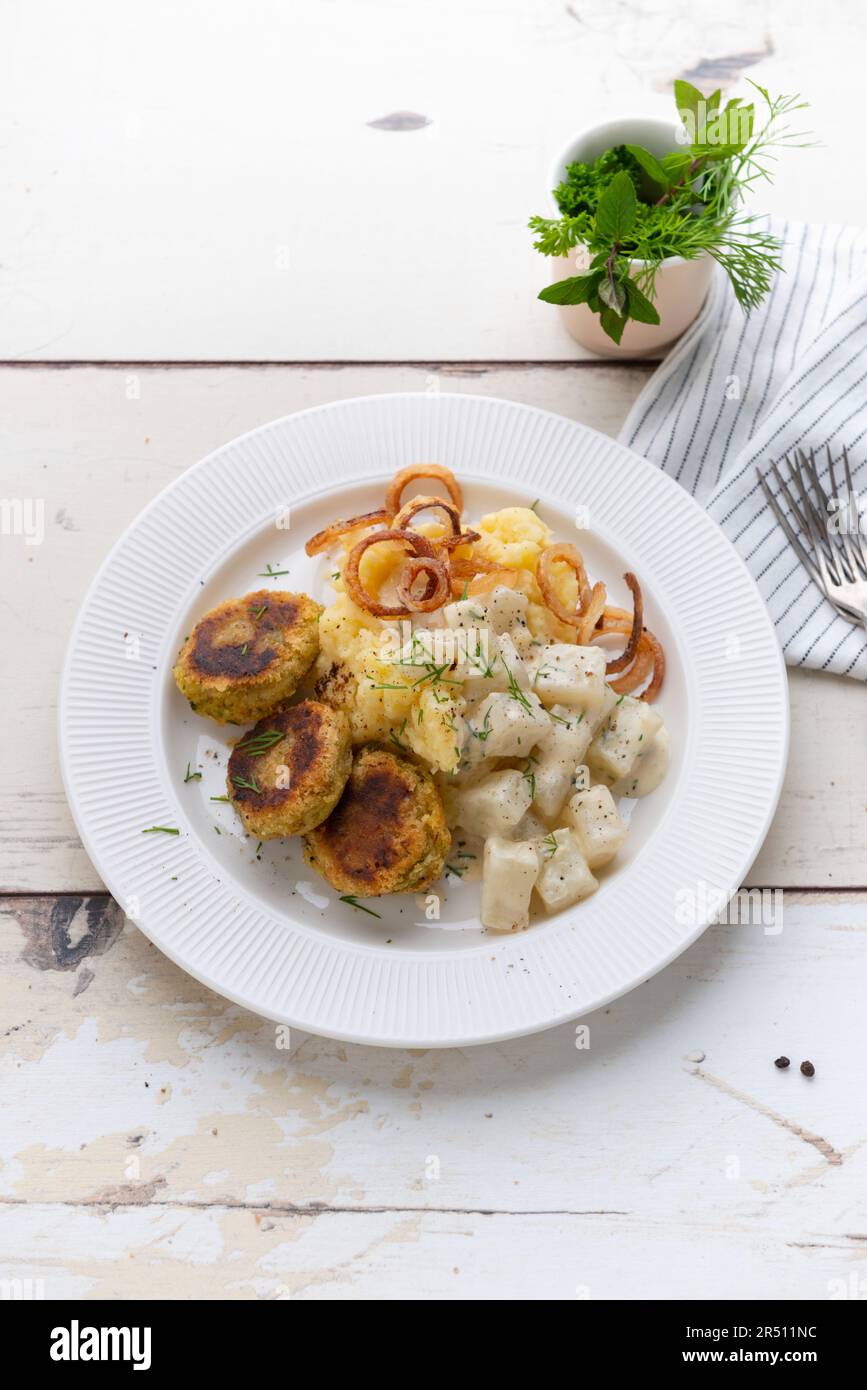 Patties de lentilles jaunes avec purée de pommes de terre, chou-rave crémeux et oignons rôtis (vegan) Banque D'Images