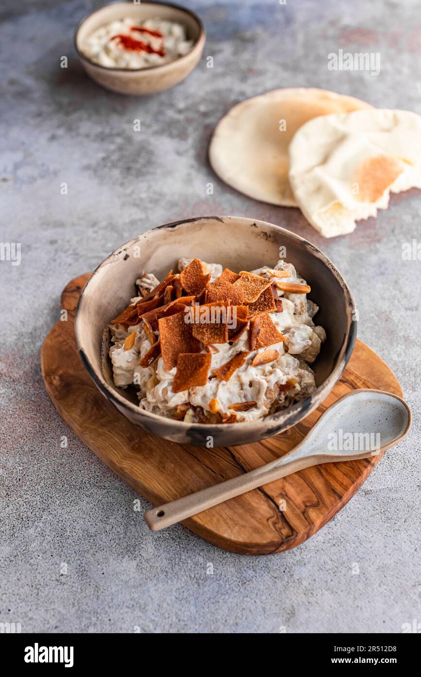 Le Fatte ou Fatteh de pois chiches est un plat libanais populaire de pain pita croquant recouvert de pois chiches chauds et de yaourt Banque D'Images