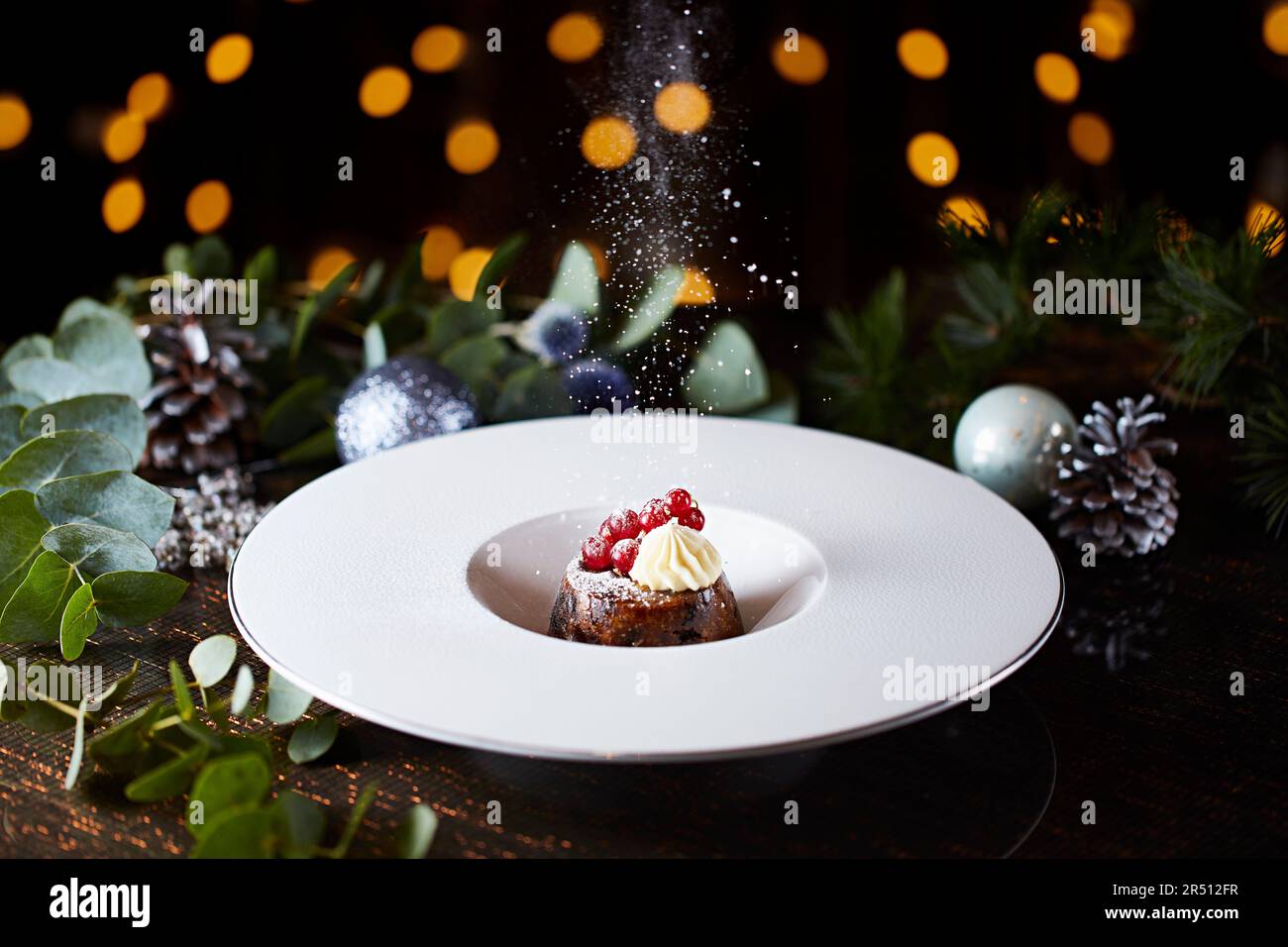 Un pudding de Noël est dépoussiéré avec du sucre glace Banque D'Images