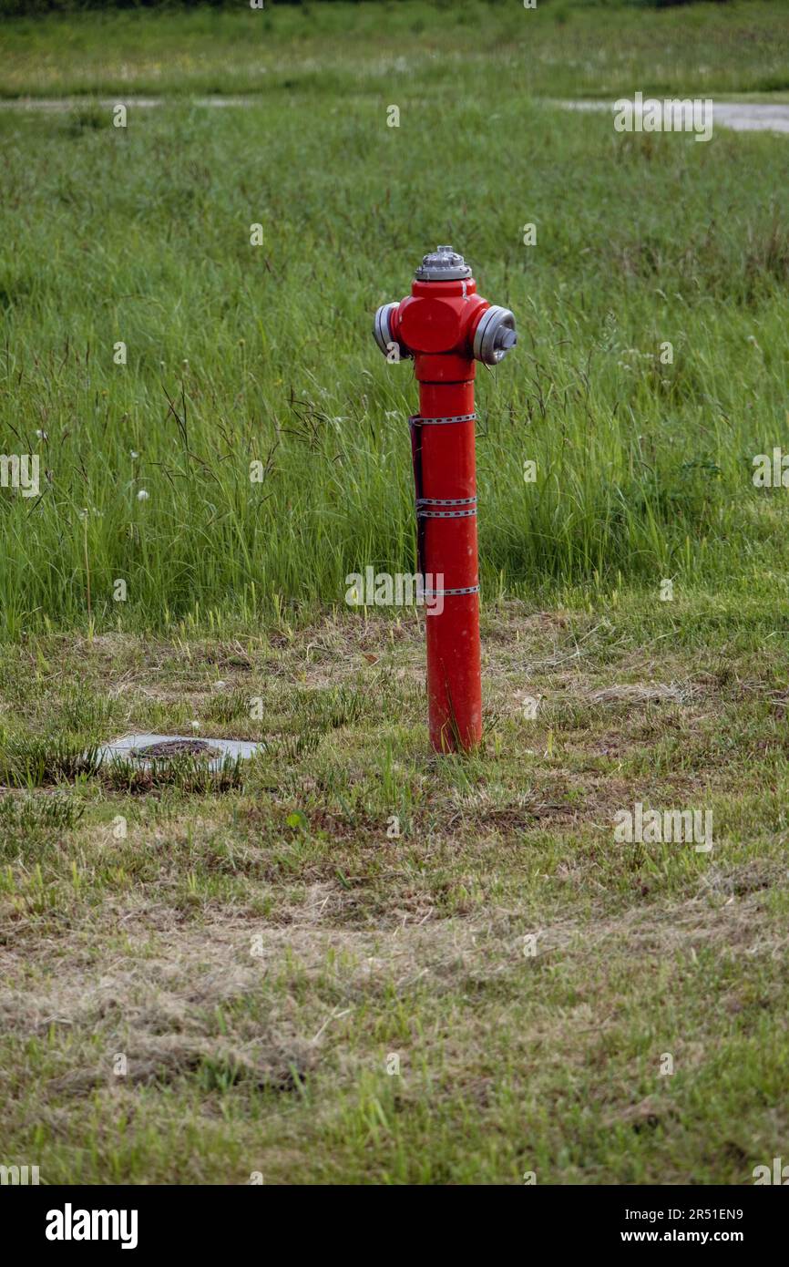 Borne d'incendie sur le terrain - tuyau rouge avec eau Banque D'Images