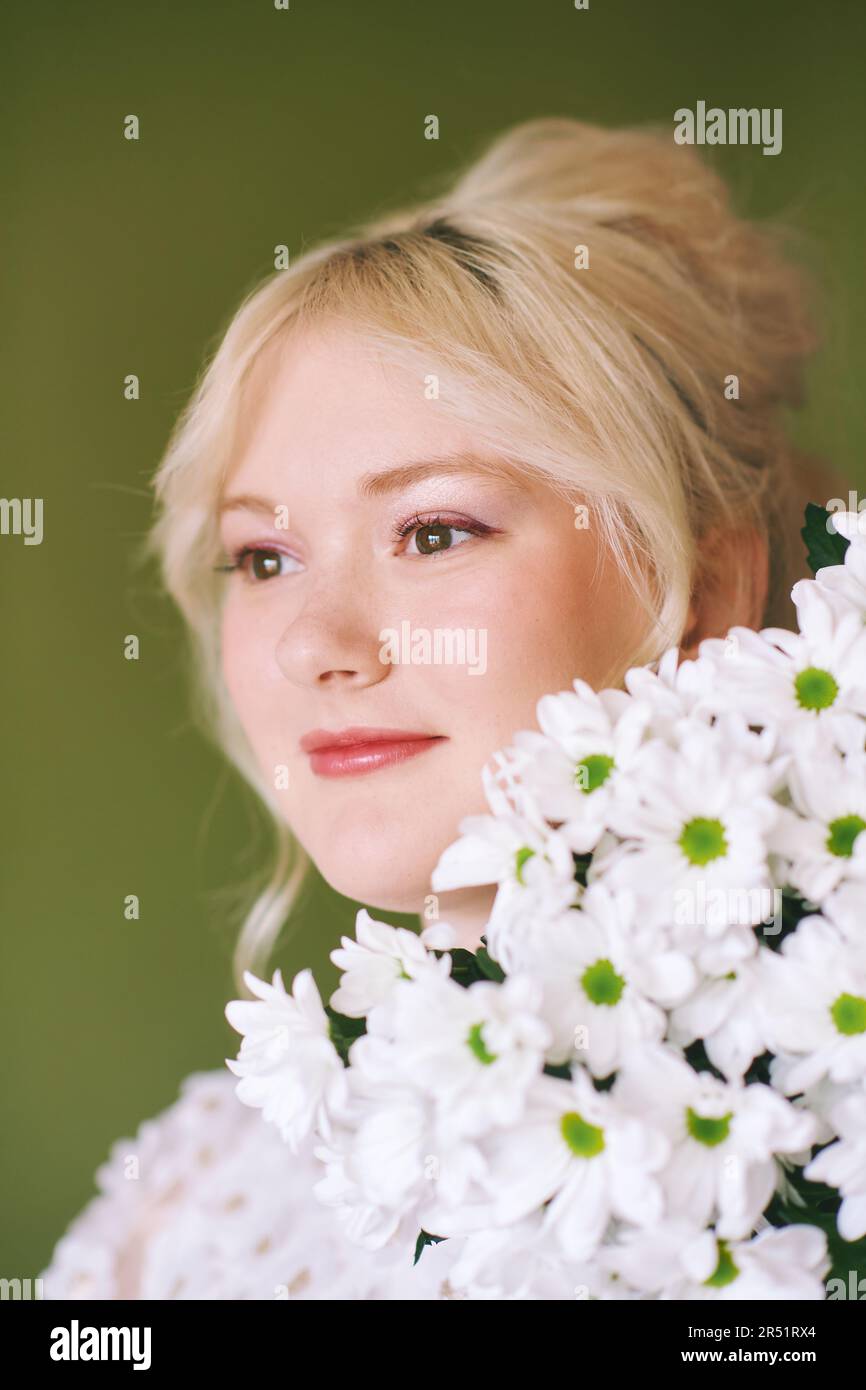 Portrait de beauté de jolie jeune fille de 15 - 16 ans teeenage portant une robe blanche posant sur fond vert Banque D'Images