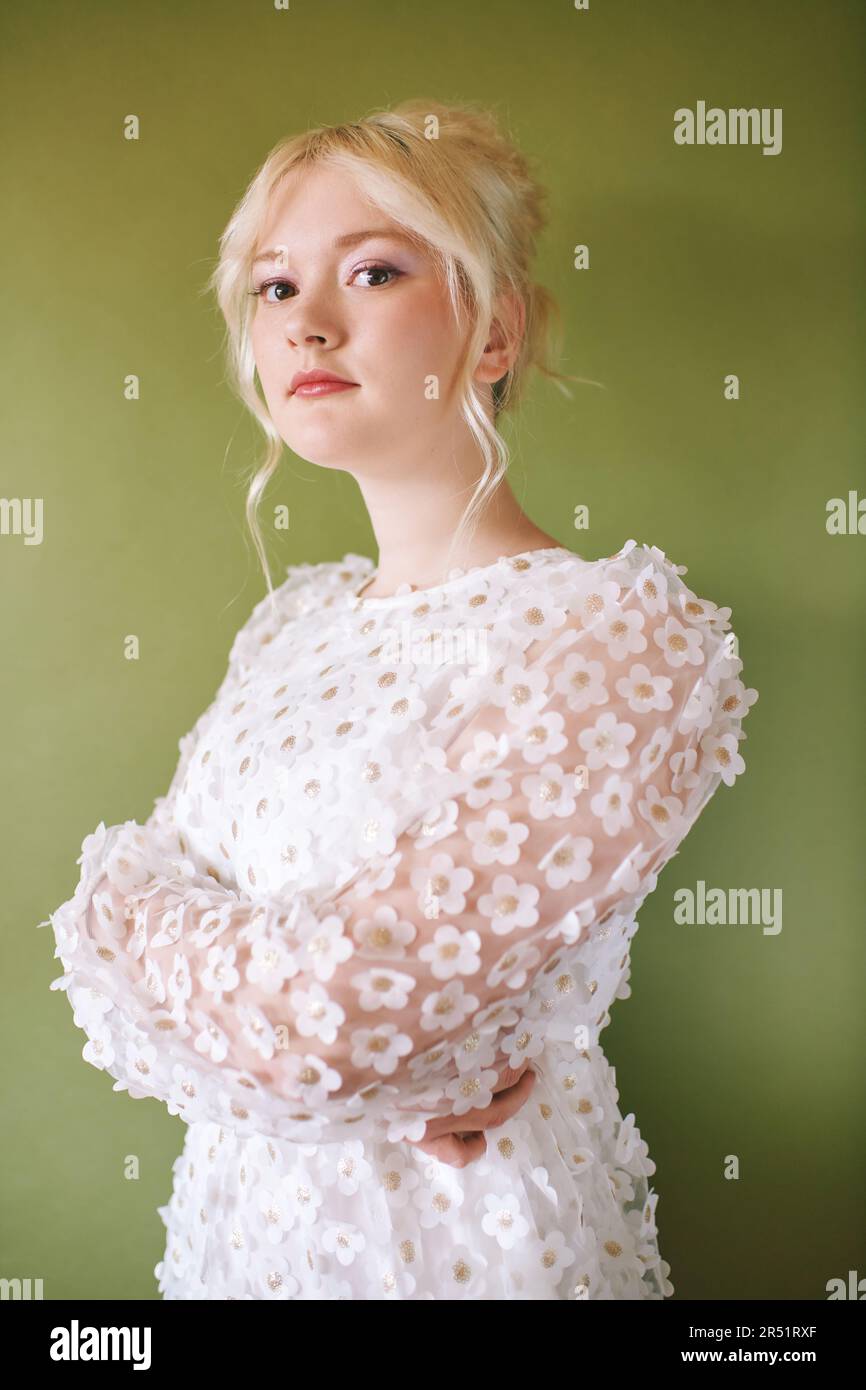 Portrait de beauté de jolie jeune fille de 15 - 16 ans teeenage portant une robe blanche posant sur fond vert Banque D'Images