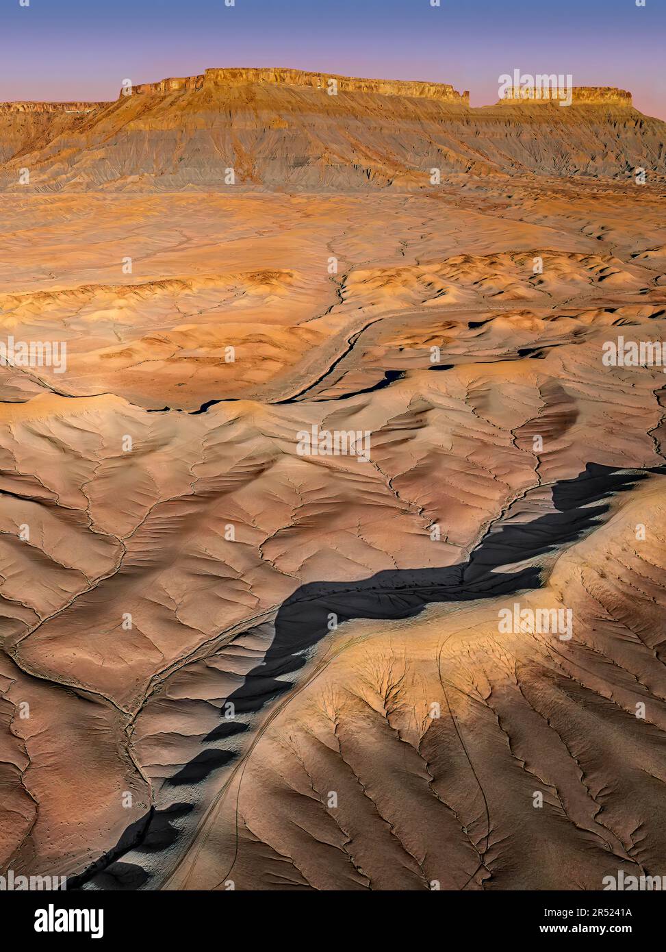 Badlands de l'Utah aérien - vue sur Drone pendant l'heure d'or par North Cainville Mesa dans les Badlands du sud de l'Utah. Les nombreuses couches du sont visibles Banque D'Images