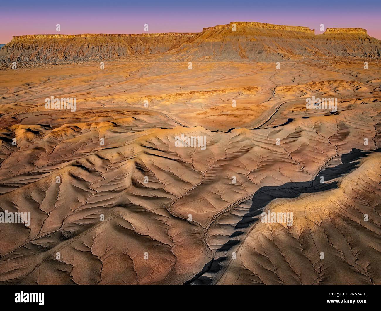 Badlands de l'Utah aérien - vue sur Drone pendant l'heure d'or par North Cainville Mesa dans les Badlands du sud de l'Utah. Les nombreuses couches du sont visibles Banque D'Images