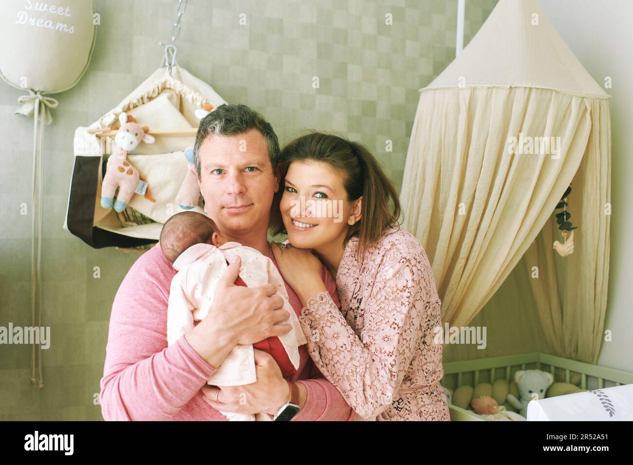 Famille heureuse avec bébé, la première fois parents tenant la fille nouveau-né Banque D'Images
