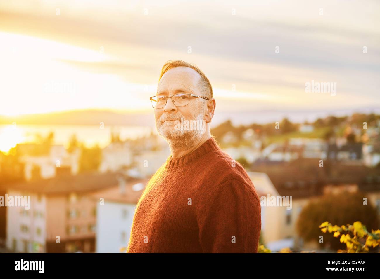 Portrait extérieur de l'homme d'âge moyen en plein soleil, ville en arrière-plan Banque D'Images