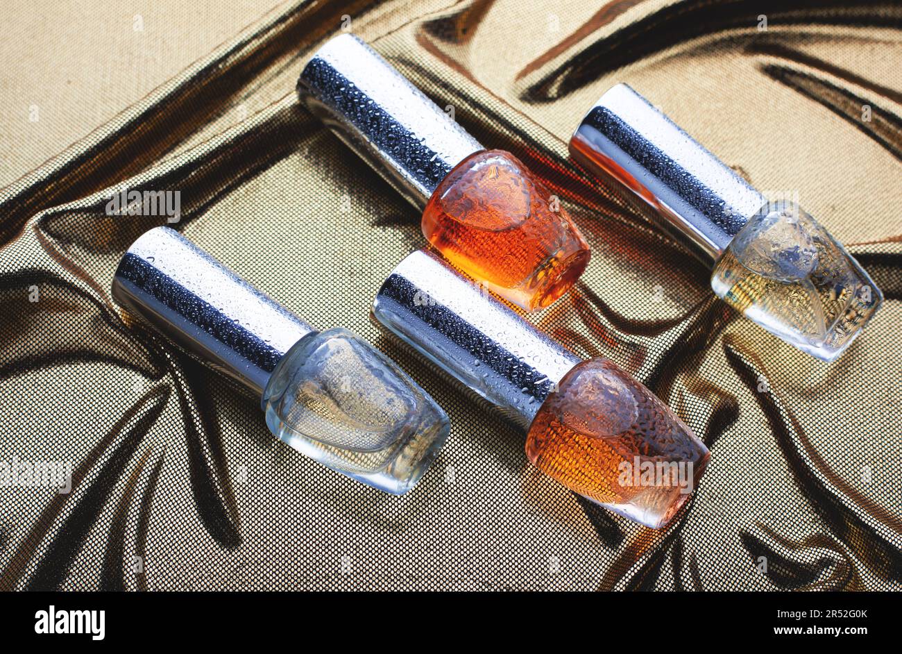 différentes bouteilles de parfum sont sur le tissu doré Banque D'Images