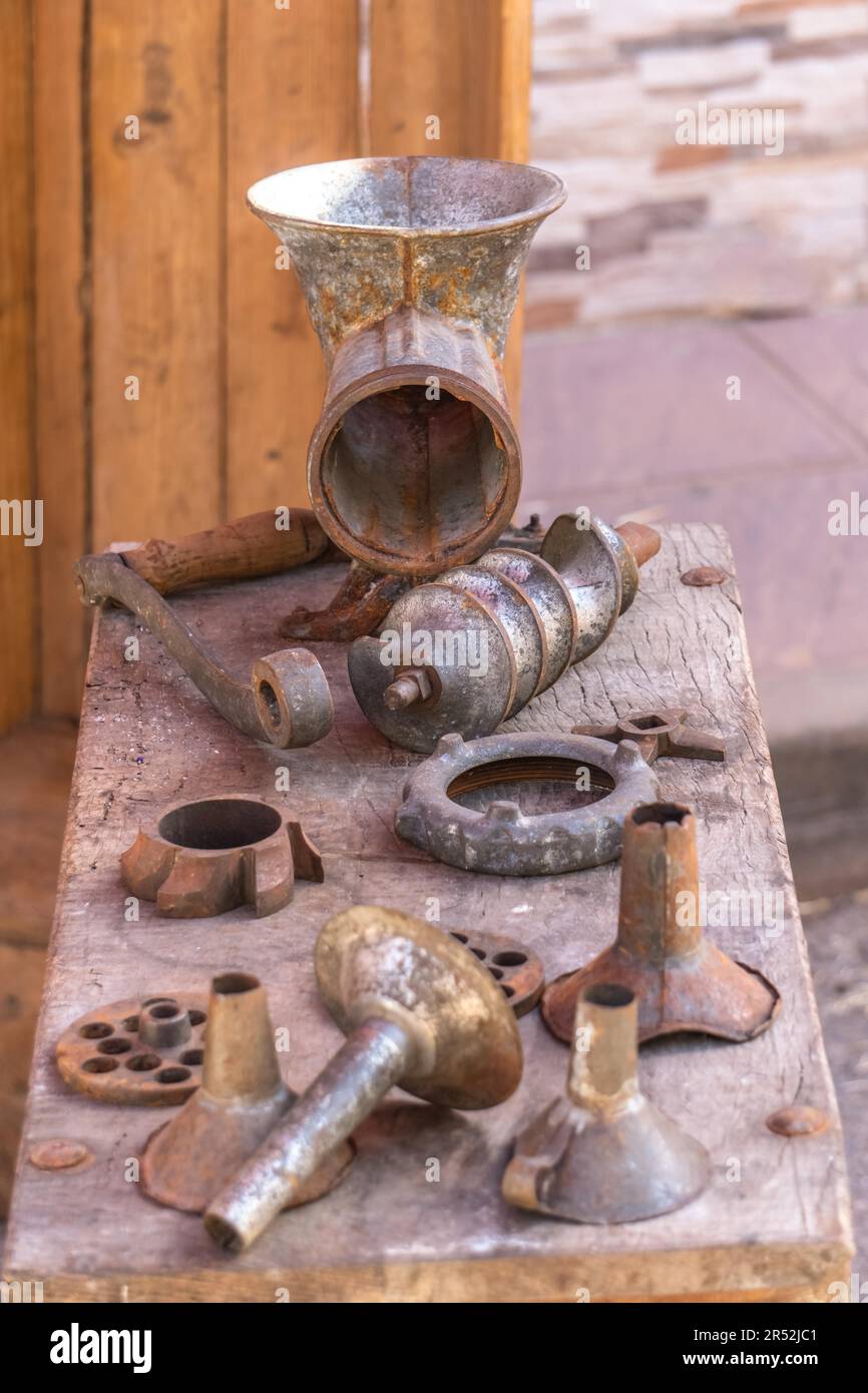 Machine à saucisse antique avec tous ses accessoires sur une table en bois Banque D'Images