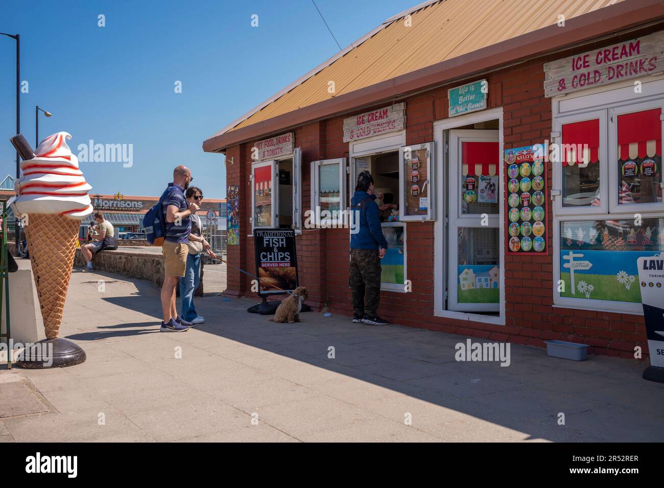 Les gens achètent et mangent de la glace sur West Kirby Beach Banque D'Images