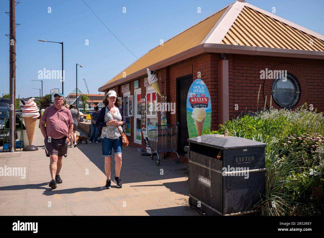 Les gens achètent et mangent de la glace sur West Kirby Beach Banque D'Images