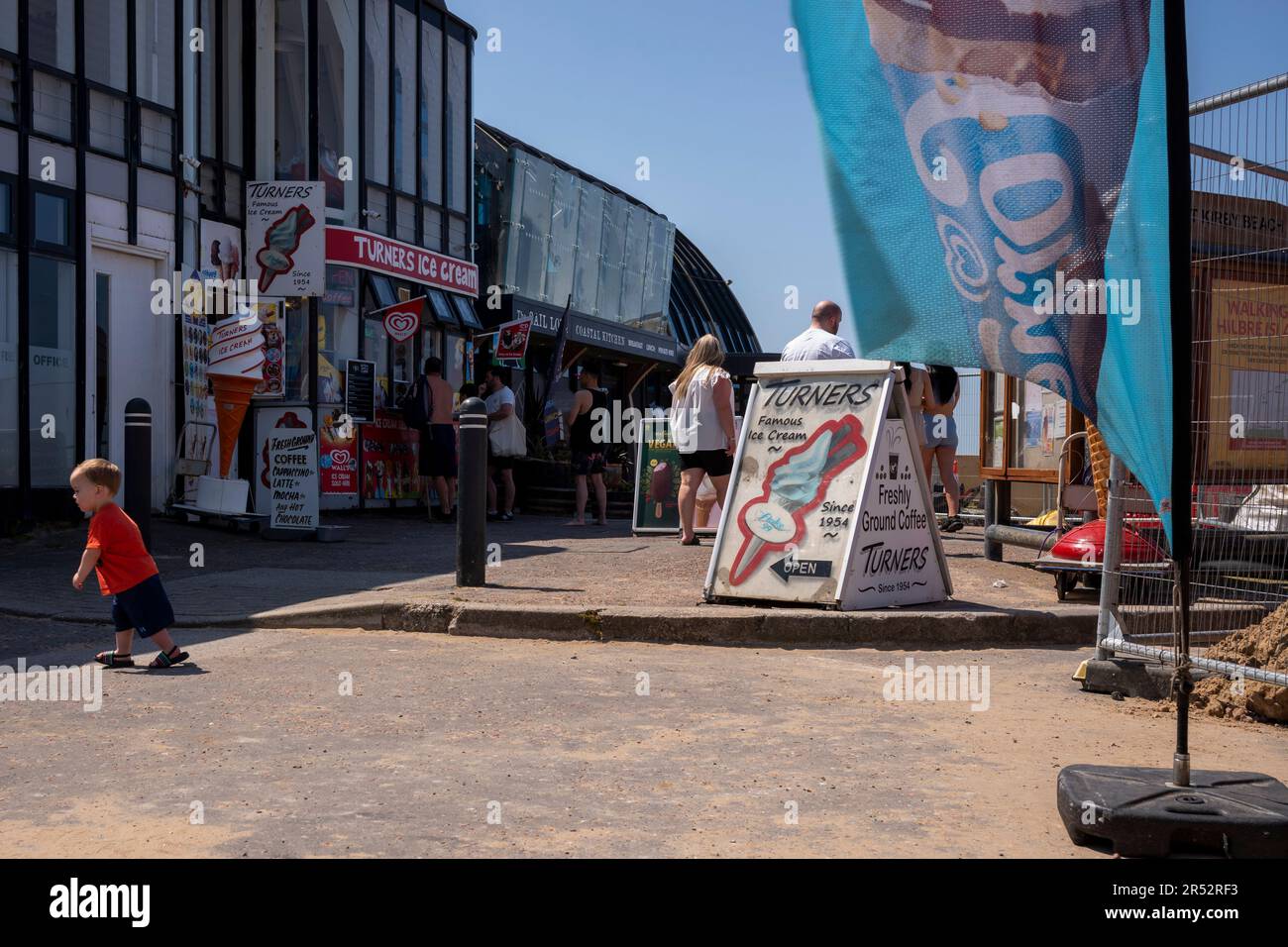 Les gens achètent et mangent de la glace sur West Kirby Beach Banque D'Images