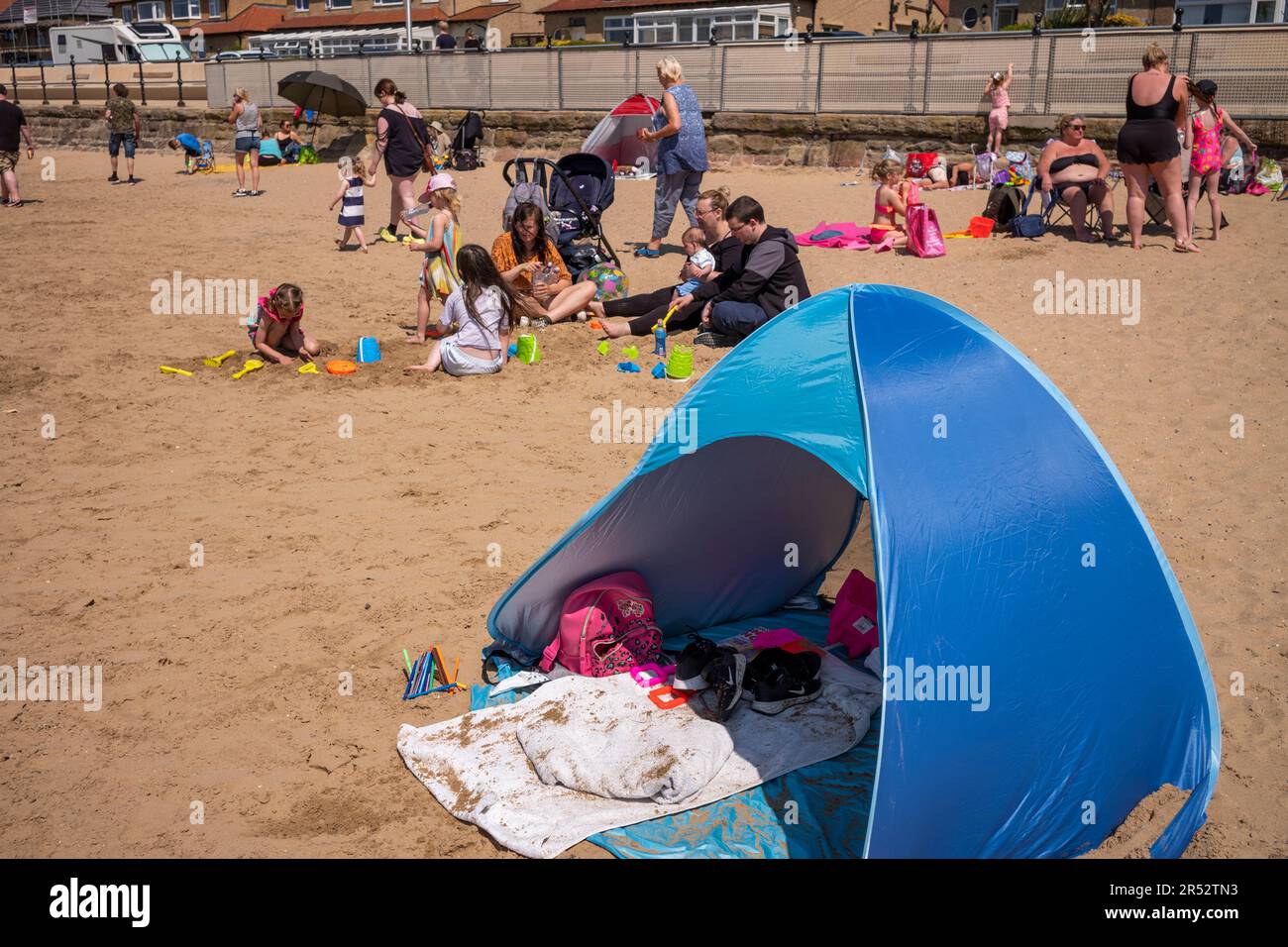 Les gens achètent et mangent de la glace sur West Kirby Beach Banque D'Images