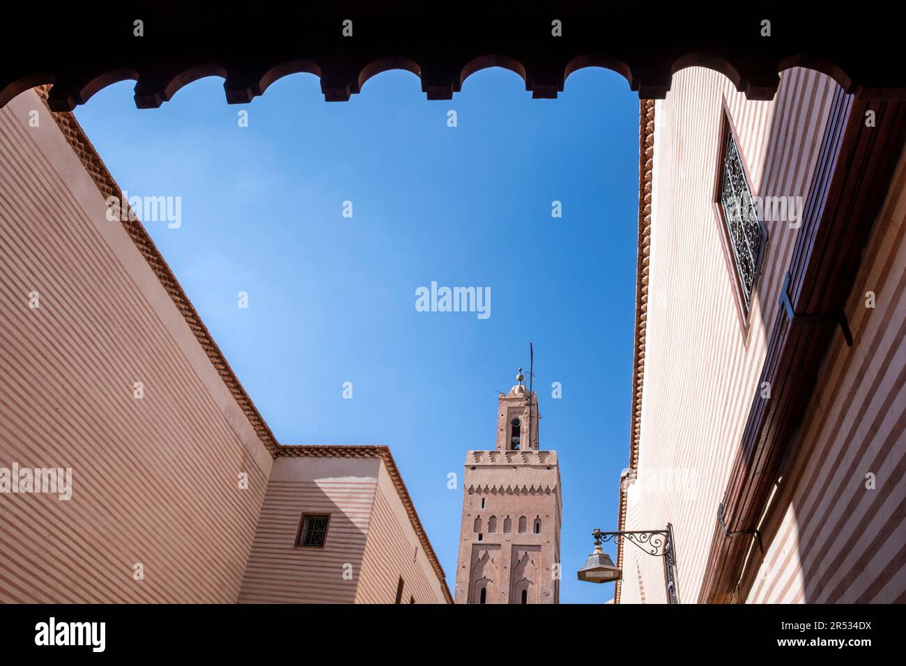 Un minaret et brickwork rayé dans la vieille ville de Marrakech, au Maroc Banque D'Images