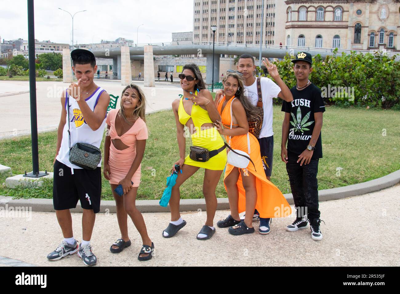 Des jeunes amis cubains souriants et chaleureux donnent des coups de pouce sur le Malecon à la Havane, Cuba. Banque D'Images