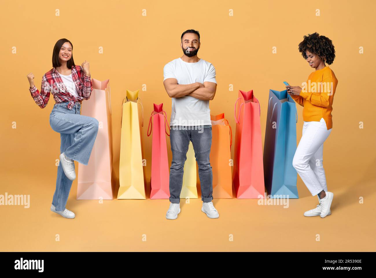 Jeunes multiraciaux souriants qui apprécient la vente de saison, le collage Banque D'Images