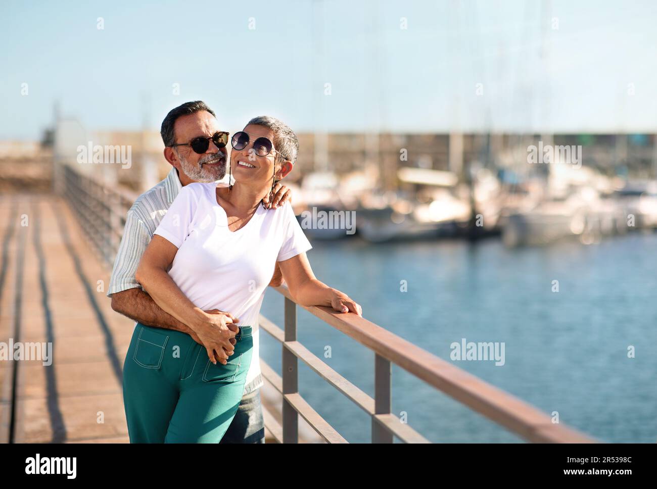 Joyeux conjoints mûrs s'embrassant debout près de Yachts à Sea Marina Banque D'Images