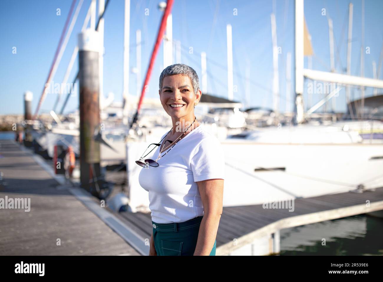 Bonne femme mûre debout près de Yachts à Marina appréciant des vacances Banque D'Images
