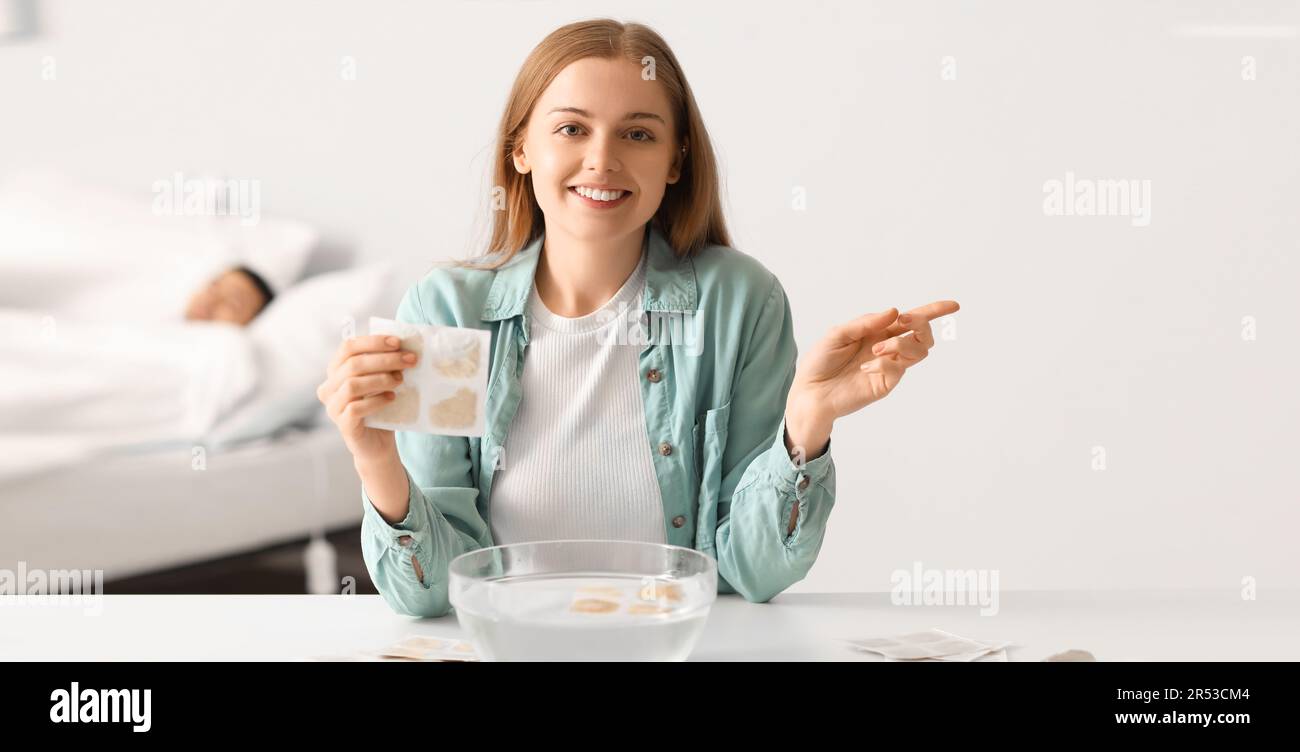 Jeune femme avec du plâtre à la moutarde à la maison Banque D'Images