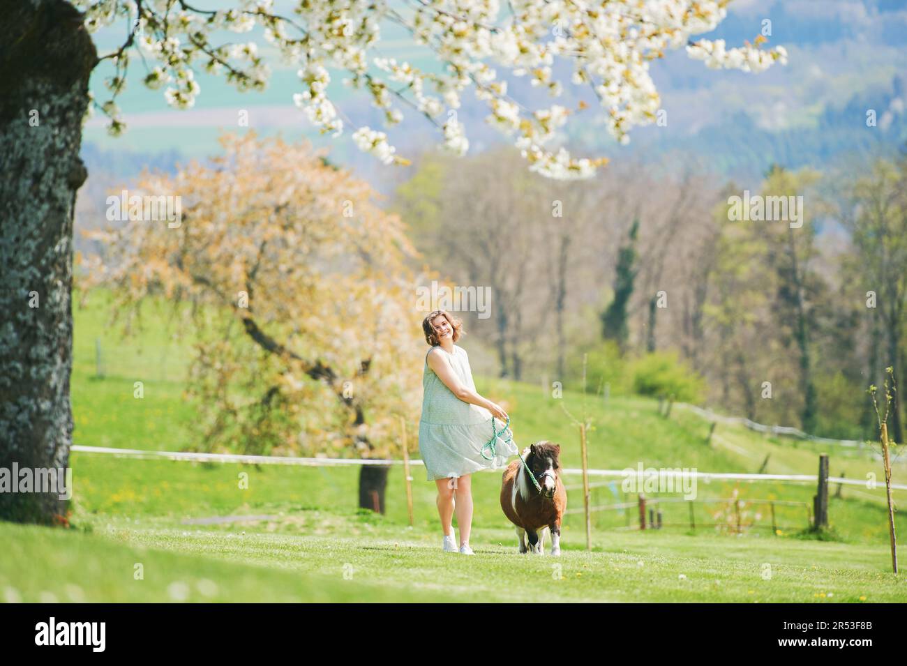 Portrait extérieur de la jeune femme heureuse jouant avec du poney, vacances à la ferme Banque D'Images